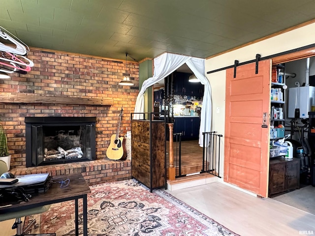 living area featuring a barn door, a fireplace, and brick wall