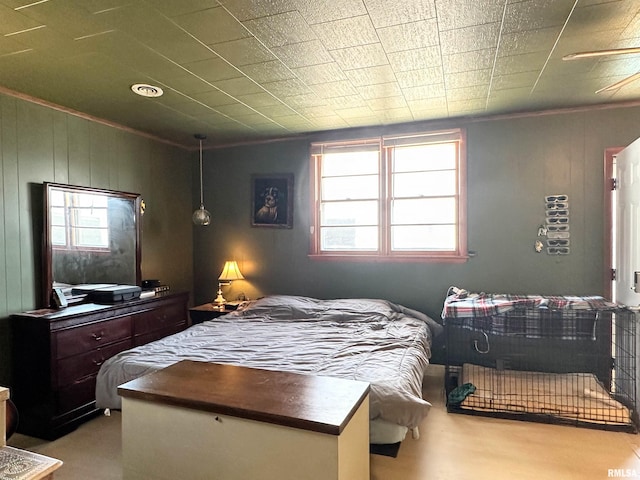 bedroom with crown molding, multiple windows, and wood finished floors