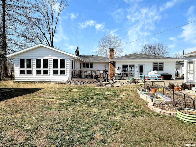 rear view of property with a wooden deck, a yard, and a chimney