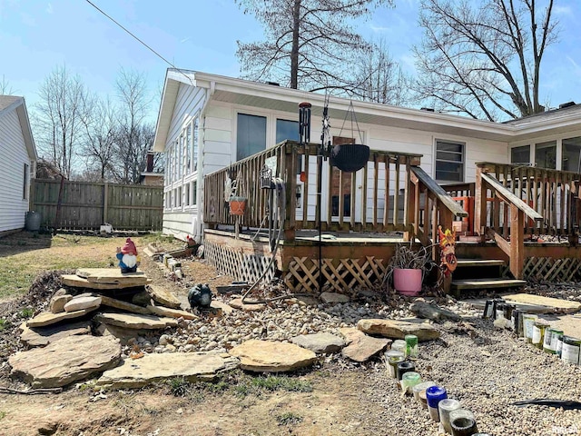 back of property with fence and a wooden deck