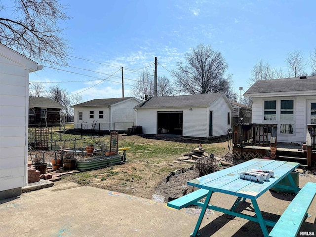 view of yard featuring an outbuilding, fence, a garage, and a wooden deck