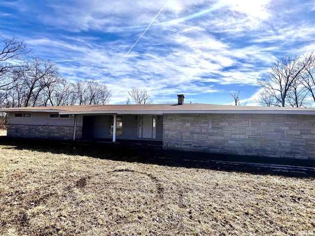 back of house featuring stone siding