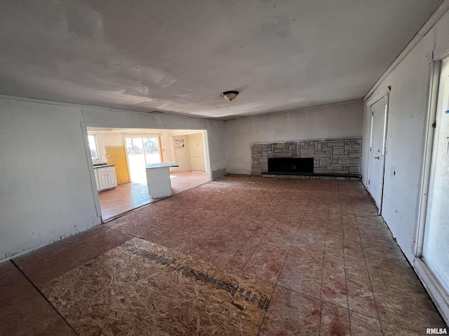 unfurnished living room featuring a stone fireplace