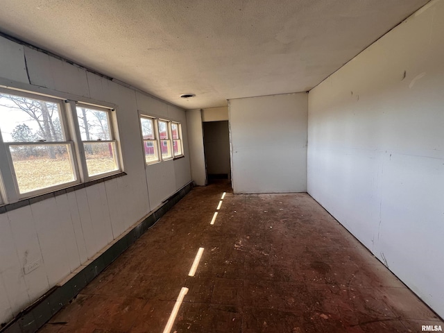 unfurnished room with a textured ceiling