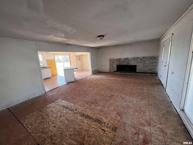 unfurnished living room with a stone fireplace