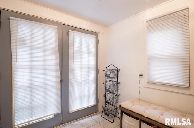 sitting room with light tile patterned floors and ornamental molding