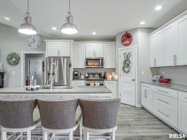 kitchen with recessed lighting, stainless steel appliances, white cabinets, and light wood-style flooring
