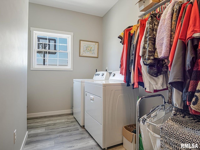 laundry room featuring laundry area, separate washer and dryer, baseboards, and light wood finished floors