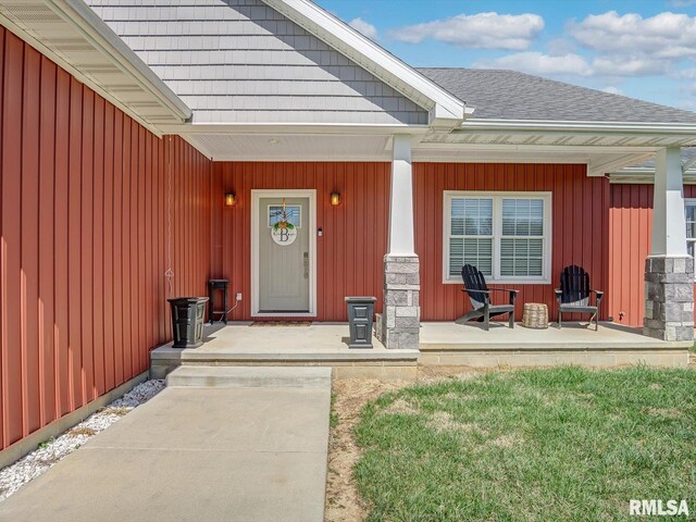 entrance to property with roof with shingles and covered porch