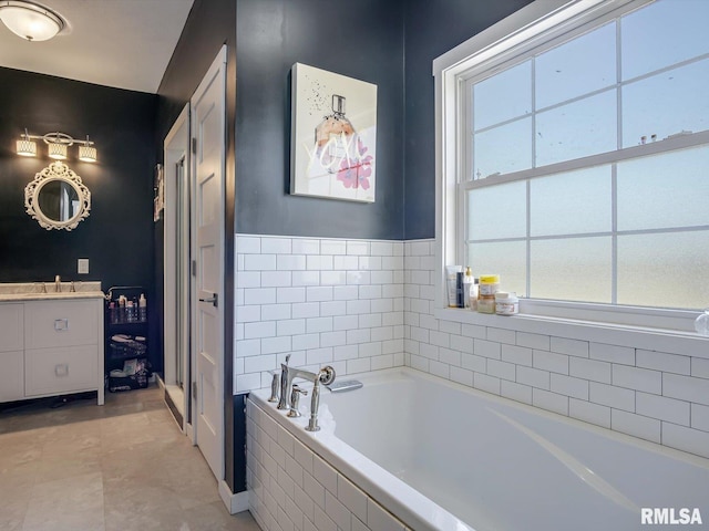 bathroom with vanity and a garden tub