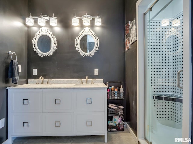 full bathroom featuring double vanity, a stall shower, and a sink