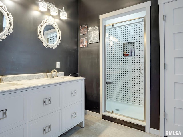 bathroom featuring double vanity, a shower stall, baseboards, and a sink