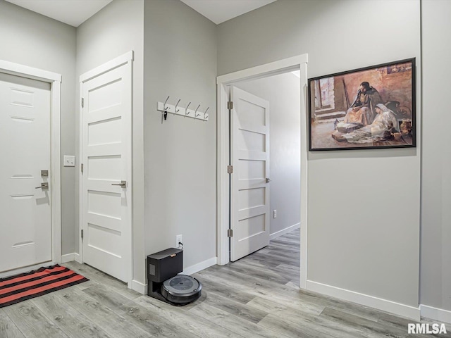 entryway with baseboards and light wood finished floors