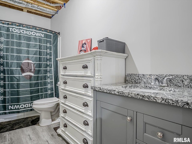 full bathroom featuring vanity, a shower with curtain, toilet, and wood finished floors