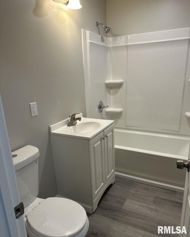 full bathroom with toilet, wood finished floors, vanity, and shower / tub combination