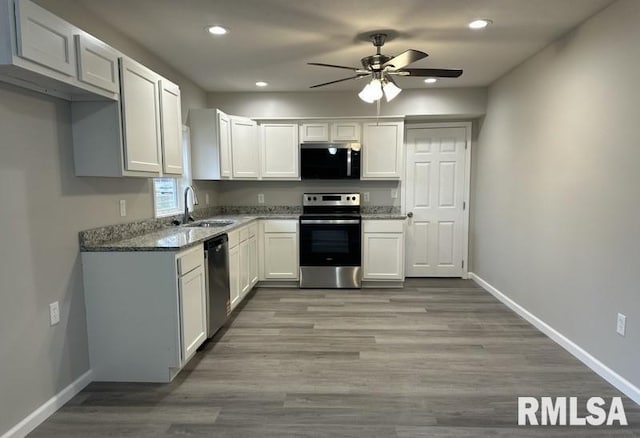 kitchen featuring a ceiling fan, baseboards, stone counters, white cabinets, and appliances with stainless steel finishes