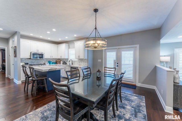 dining area featuring an inviting chandelier, recessed lighting, baseboards, and dark wood-type flooring