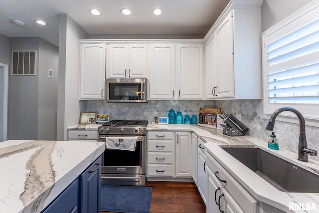kitchen featuring white cabinets, visible vents, appliances with stainless steel finishes, and a sink