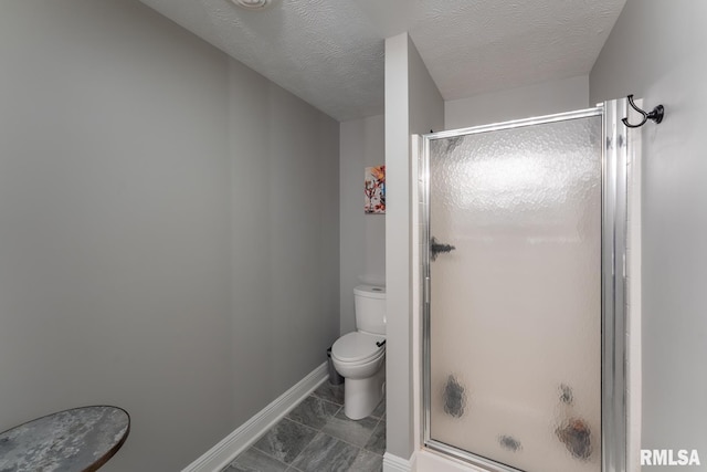 full bathroom featuring baseboards, toilet, a shower stall, and a textured ceiling