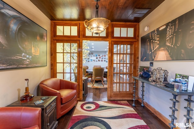 sitting room featuring dark wood-style floors, visible vents, french doors, and wood ceiling