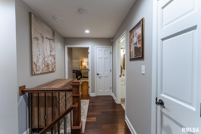 hall featuring an upstairs landing, baseboards, dark wood-style floors, and recessed lighting