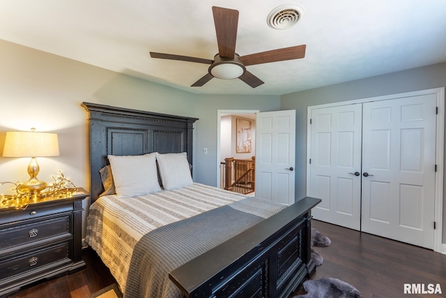 bedroom with dark wood finished floors, visible vents, ceiling fan, and a closet