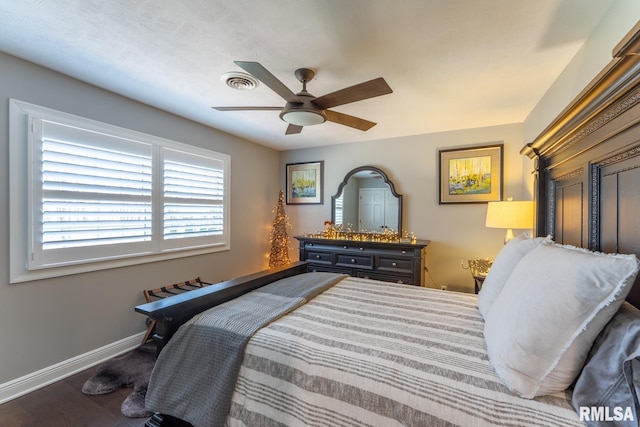 bedroom featuring visible vents, baseboards, wood finished floors, and a ceiling fan