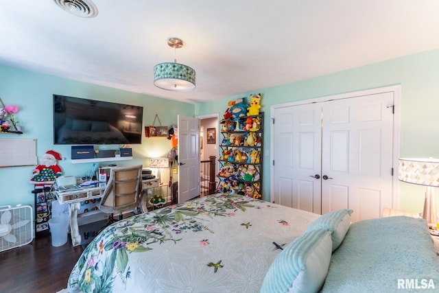 bedroom with visible vents, a closet, and wood finished floors