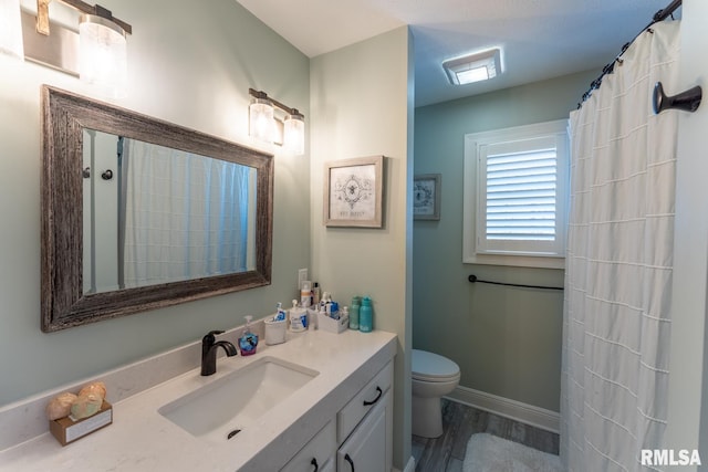 full bathroom featuring curtained shower, baseboards, toilet, wood finished floors, and vanity