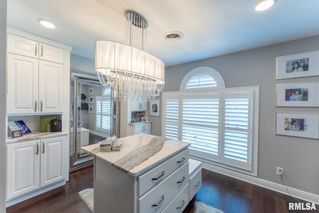 kitchen featuring white cabinets, visible vents, dark wood-style flooring, and a center island