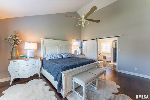 bedroom featuring a barn door, dark wood-style floors, baseboards, and ensuite bathroom