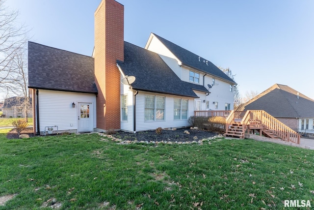 rear view of house featuring stairway, roof with shingles, a wooden deck, a yard, and a chimney