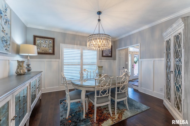 dining room with an inviting chandelier, crown molding, dark wood-style floors, and wainscoting