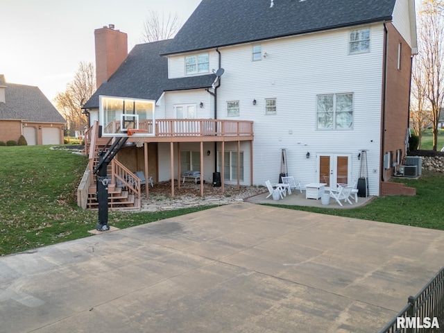 rear view of house featuring a chimney, a patio, french doors, a yard, and stairs
