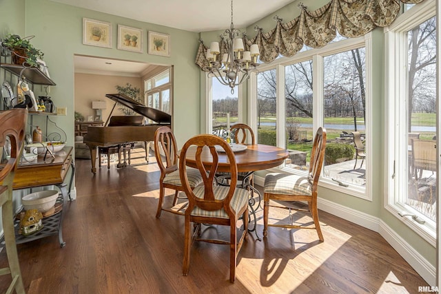 dining room with an inviting chandelier, dark wood-style floors, baseboards, and ornamental molding