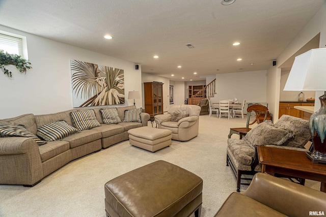 living area with light carpet, recessed lighting, and stairs