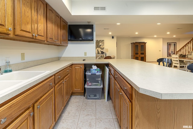 kitchen with visible vents, recessed lighting, brown cabinets, a peninsula, and light tile patterned flooring