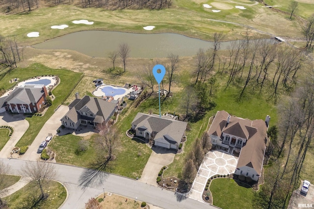 birds eye view of property with golf course view and a water view