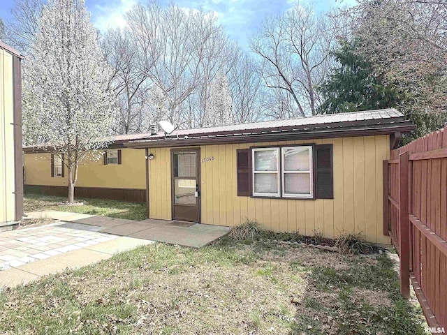 back of house featuring metal roof, a patio area, and fence