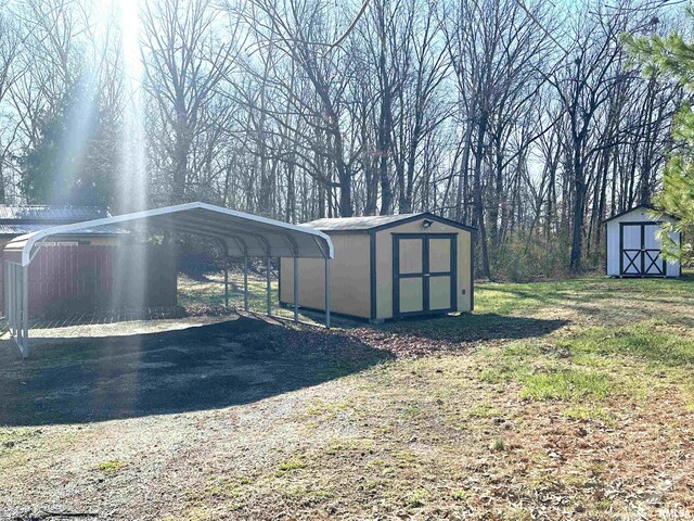 view of shed with a detached carport and driveway