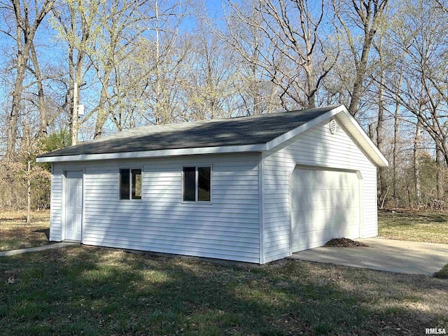 view of property exterior featuring a garage, a lawn, and an outdoor structure