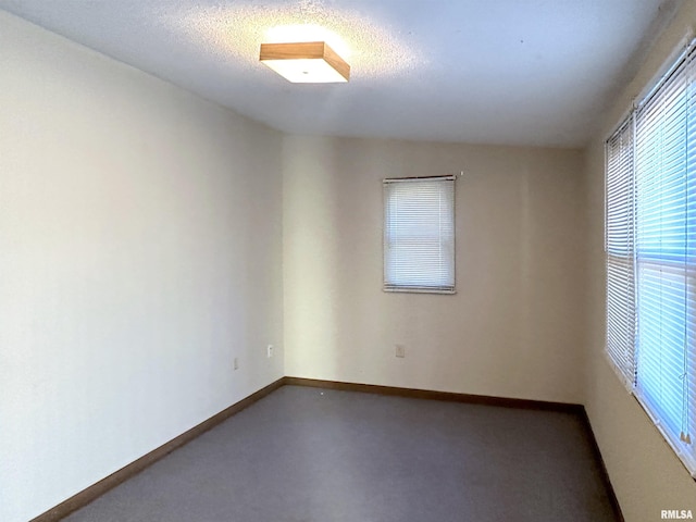 unfurnished room featuring baseboards and a textured ceiling