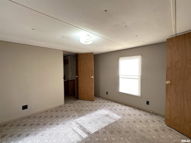 unfurnished bedroom with baseboards, carpet, and a textured ceiling