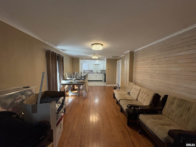 710 S Maple St, Cambria, IL 62915 - living room featuring light wood-style floors, ornamental molding, and wooden walls