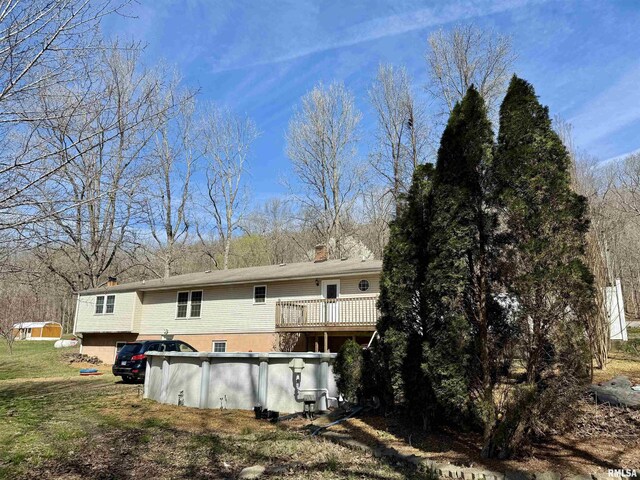 6180 Reevesville Rd, Grantsburg, IL 62943 - back of property with an outdoor pool, a chimney, and a wooden deck