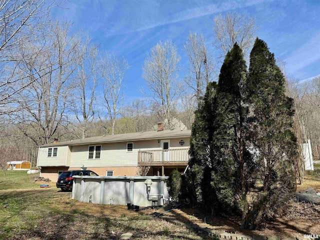 6180 Reevesville Rd, Grantsburg, IL 62943 - back of property with an outdoor pool, a chimney, and a wooden deck