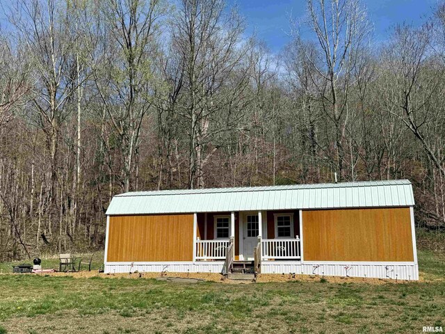 6180 Reevesville Rd, Grantsburg, IL 62943 - manufactured / mobile home featuring covered porch, a front lawn, and a view of trees