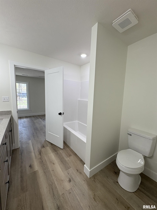 209 Madison St, Cambria, IL 62915 - bathroom with toilet, vanity, wood finished floors, a bath, and baseboards