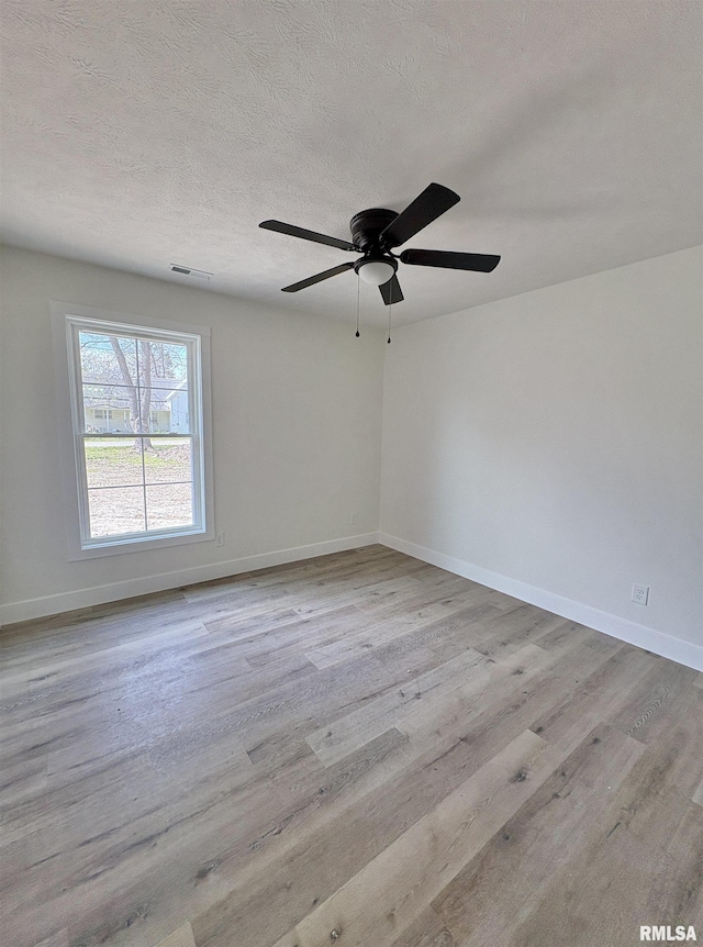 209 Madison St, Cambria, IL 62915 - spare room with wood finished floors, baseboards, a ceiling fan, and a textured ceiling