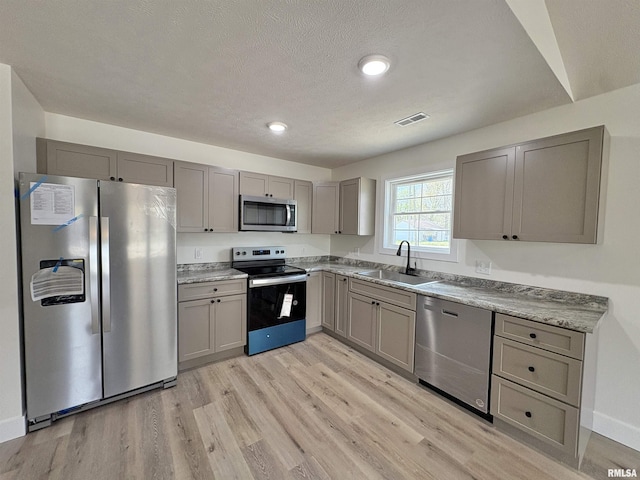 209 Madison St, Cambria, IL 62915 - kitchen featuring appliances with stainless steel finishes, a sink, gray cabinetry, light wood-style flooring, and recessed lighting